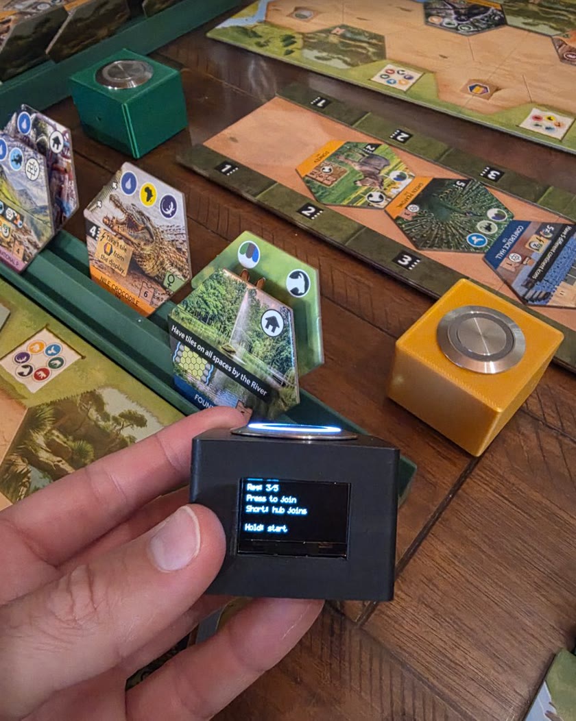 Holding an OLO turn tracker, its screen ready to join a game