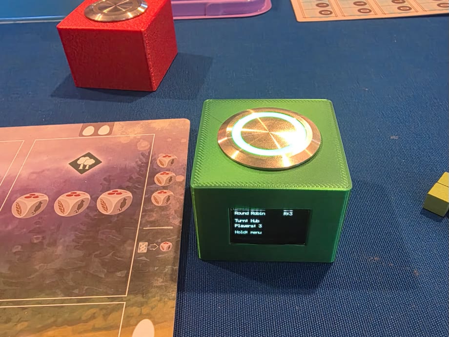 Green OLO button lit white on a game table